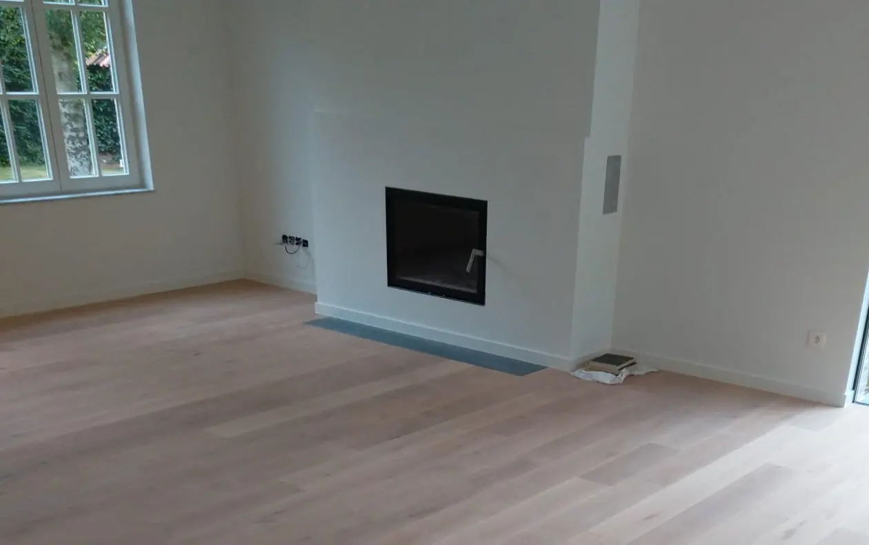 Séjour rénové avec cheminée encastrée, sole en pierre et parquet en chêne