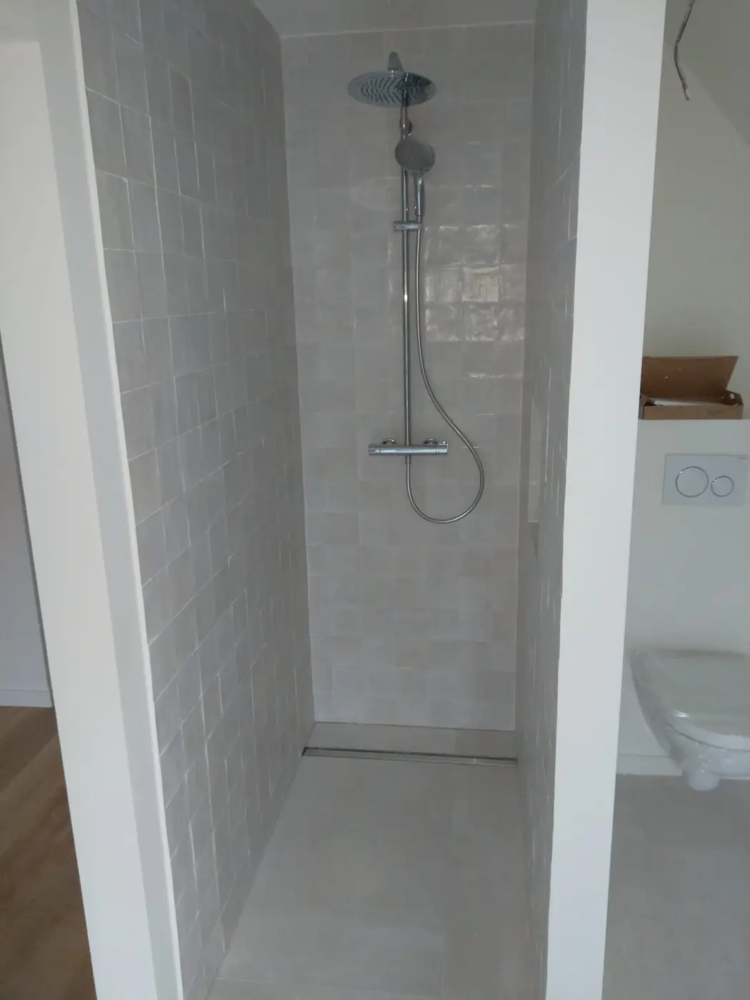 Douche à l’italienne avec faïence blanche et colonne de douche