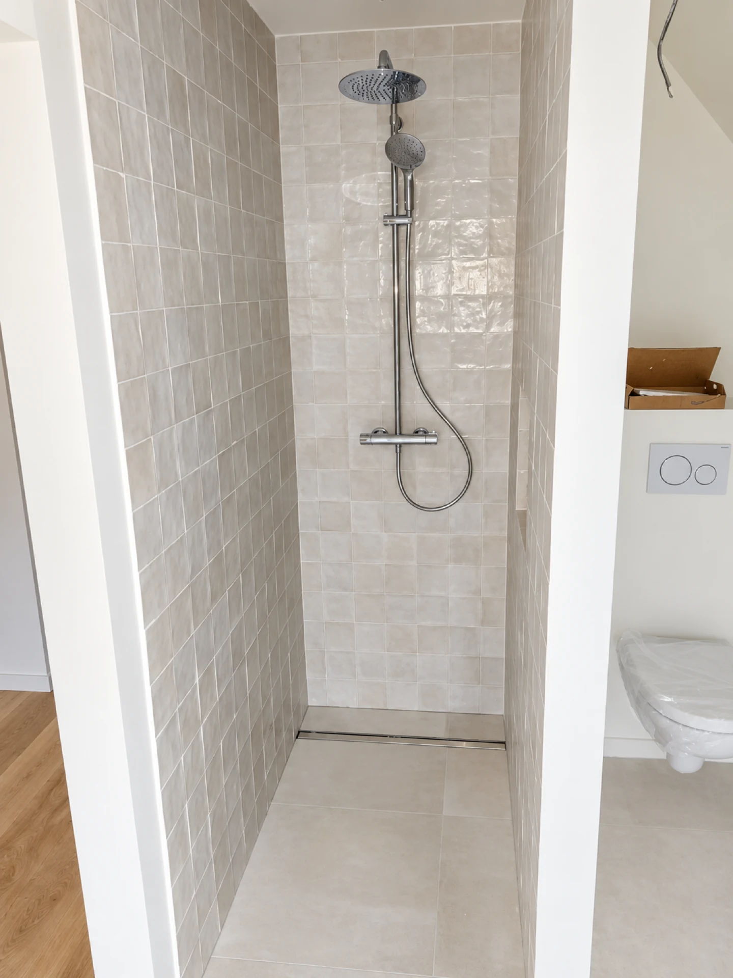Douche à l’italienne avec faïence blanche et colonne de douche