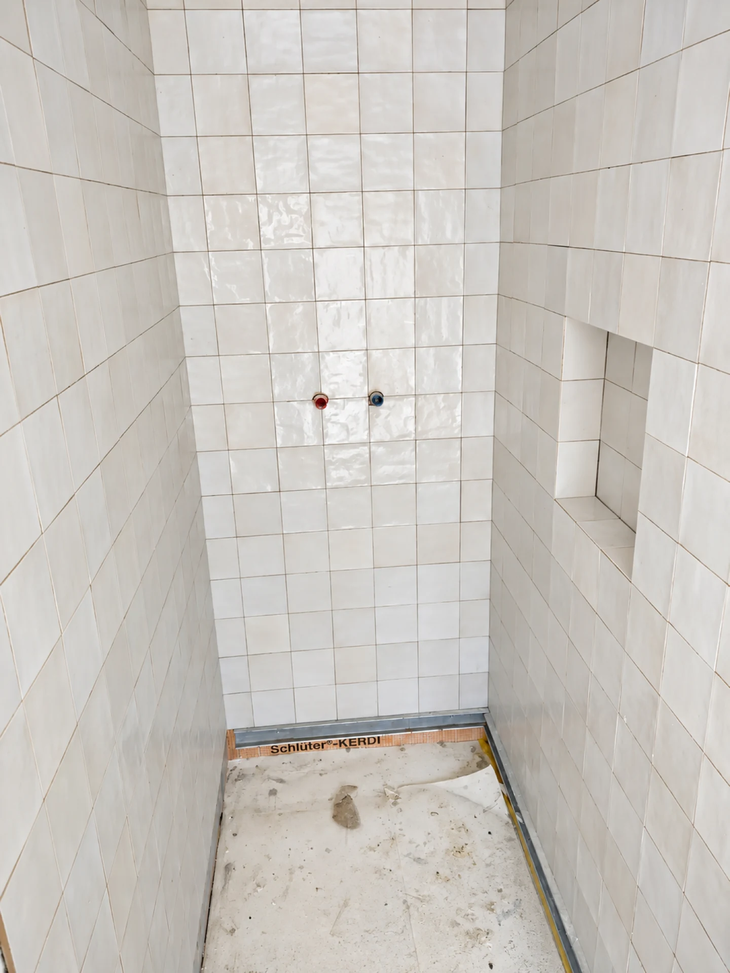Douche carrelée en faïence blanche avec niche encastrée